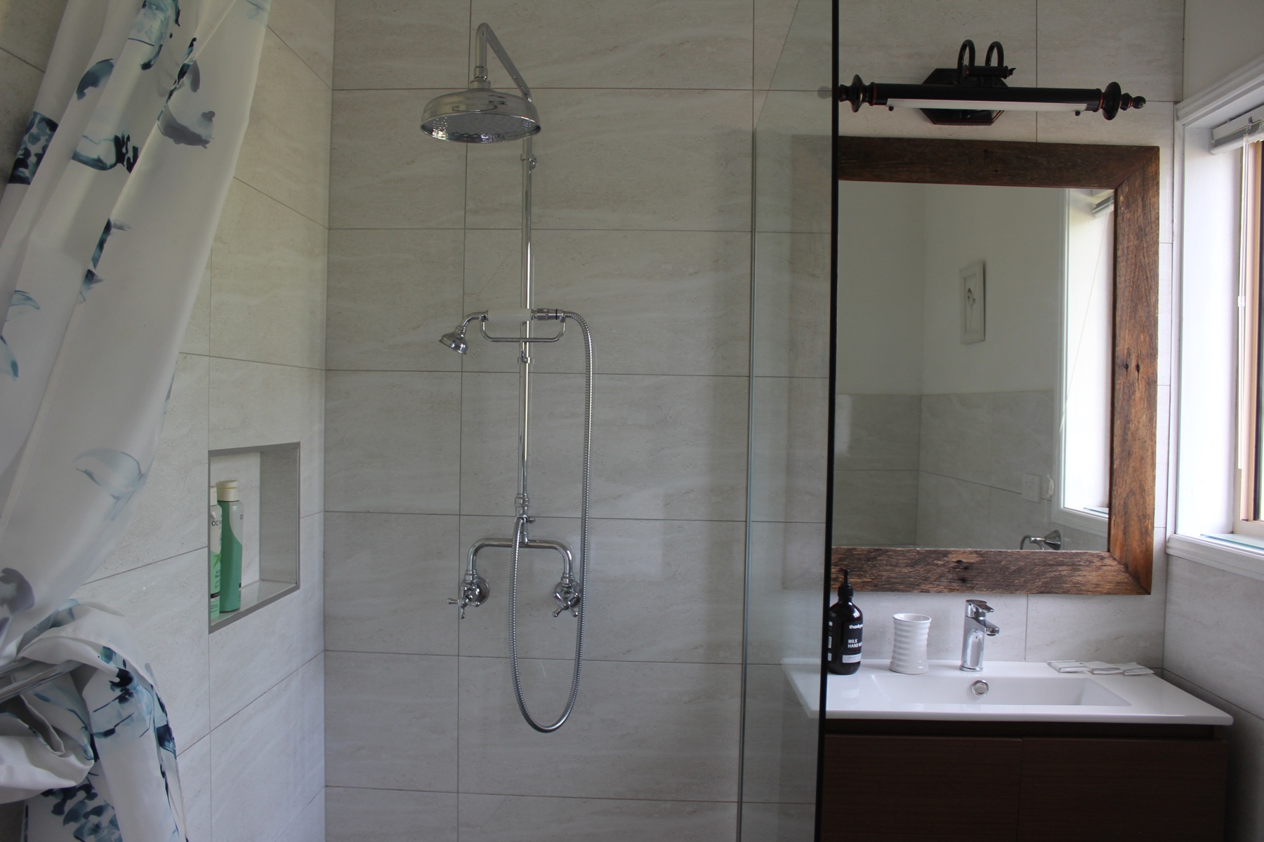 Ensuite bathroom with rain shower, timber vanity and wood-framed mirror