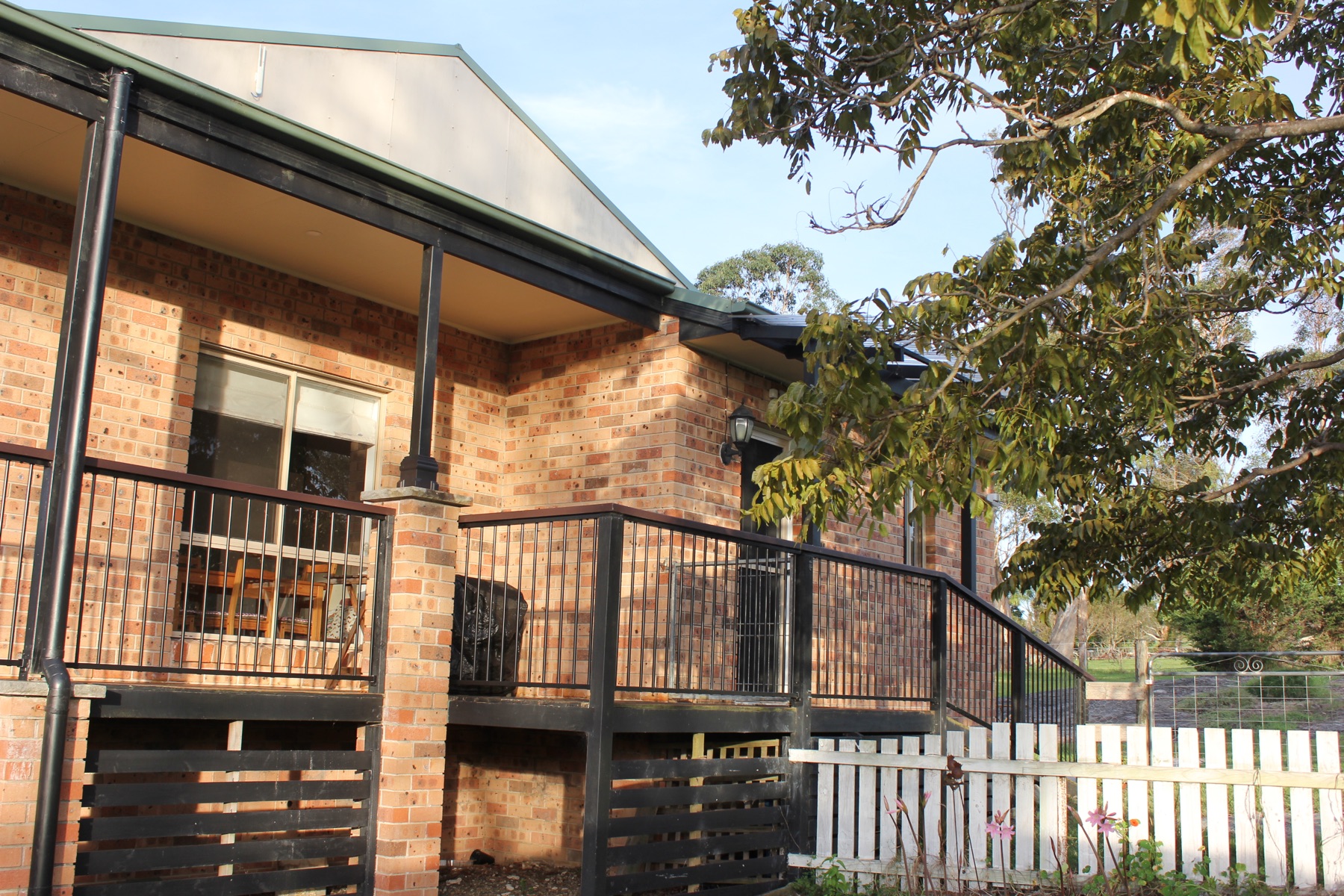 The house deck in late-afternoon light, looking toward the paddock